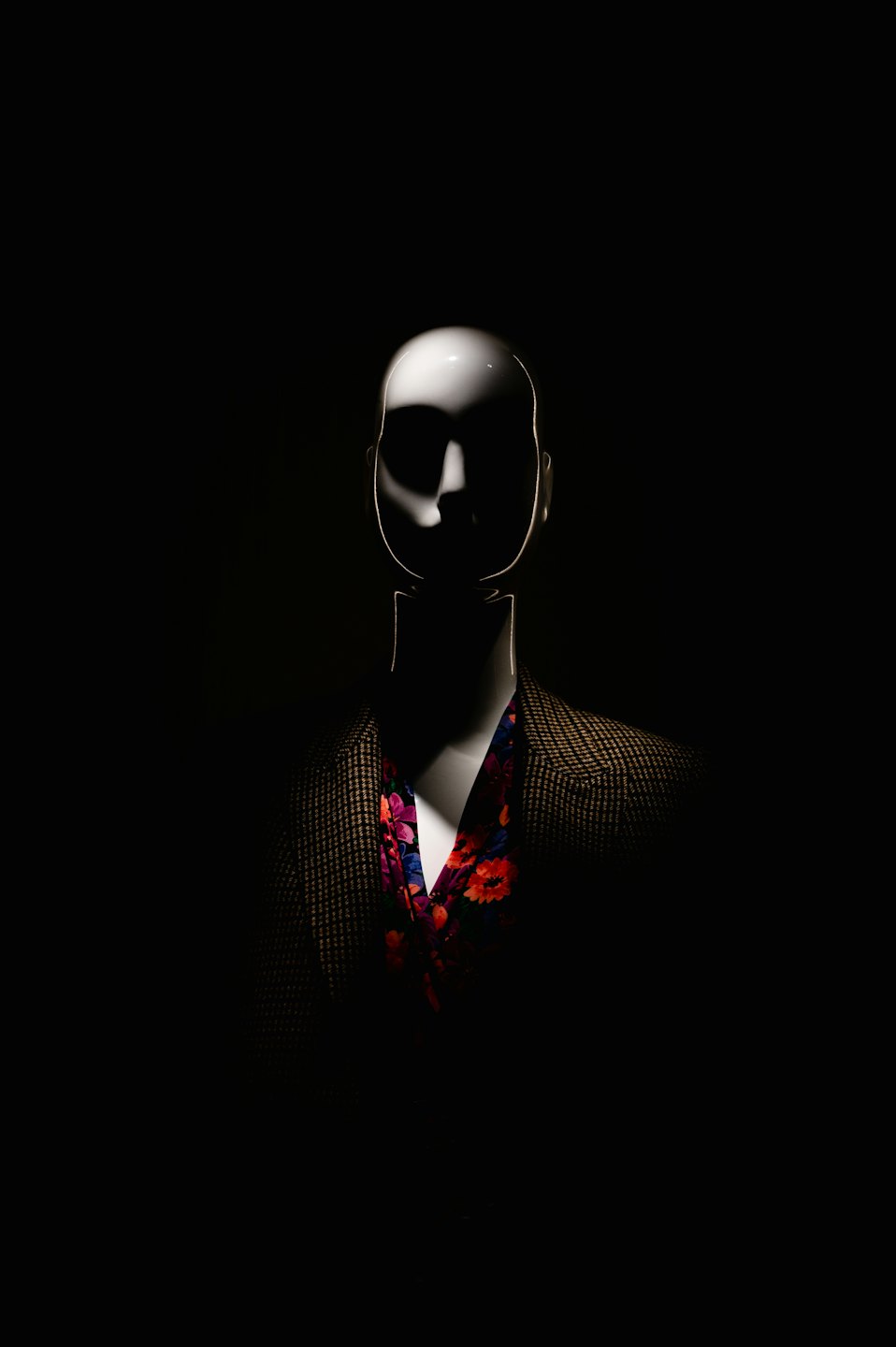 Mannequin wearing a houndstooth blazer with floral shirt.